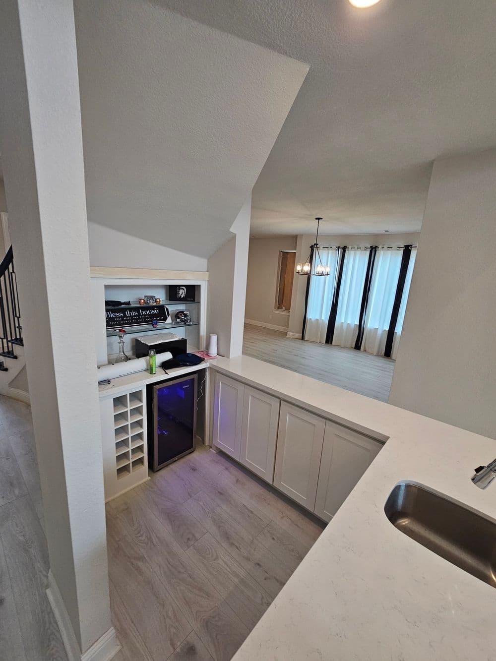 Modern kitchen with a built-in wine fridge and sleek cabinetry, featuring large windows for natural light.