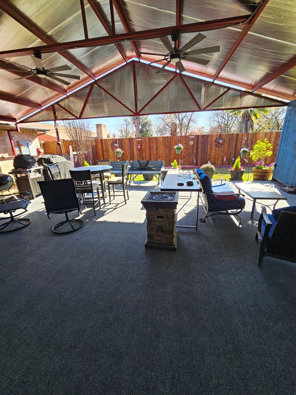 Spacious outdoor patio with seating, table arrangements, and a cozy fireplace.
