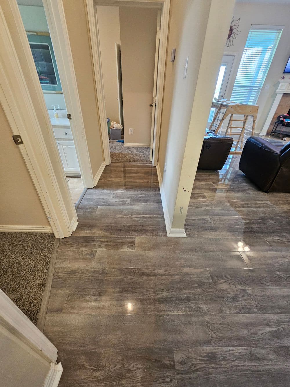 modern hallway with gray laminate flooring and adjoining rooms in a well-lit home interior