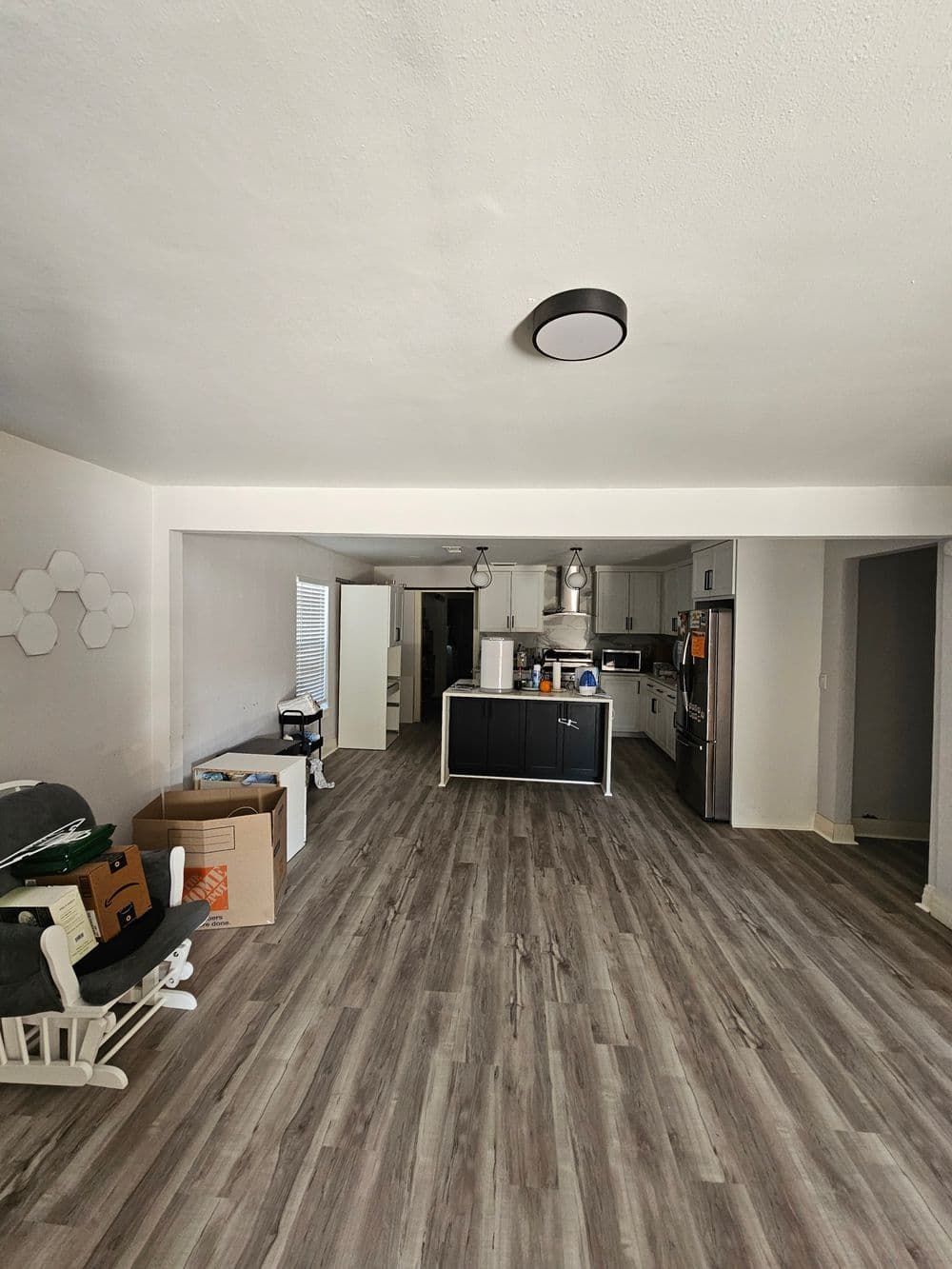 Open concept kitchen and living area with modern fixtures and storage boxes.