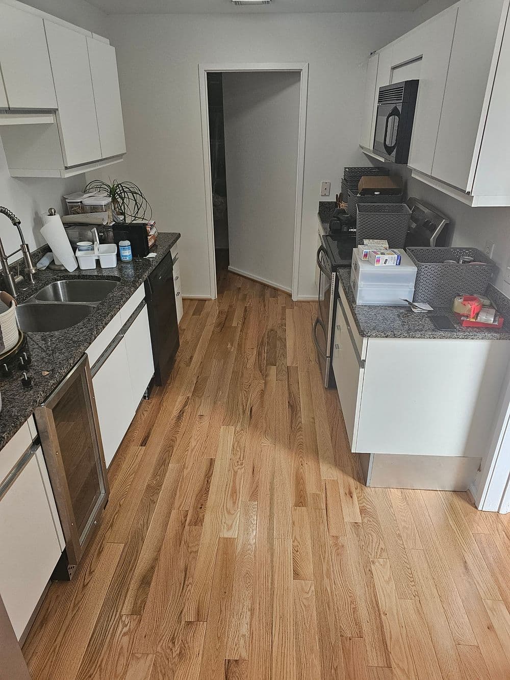 Modern kitchen with granite countertops, hardwood floors, and stainless-steel appliances.