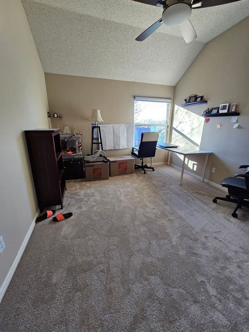 Spacious home office with a desk, chair, and natural light from a window.